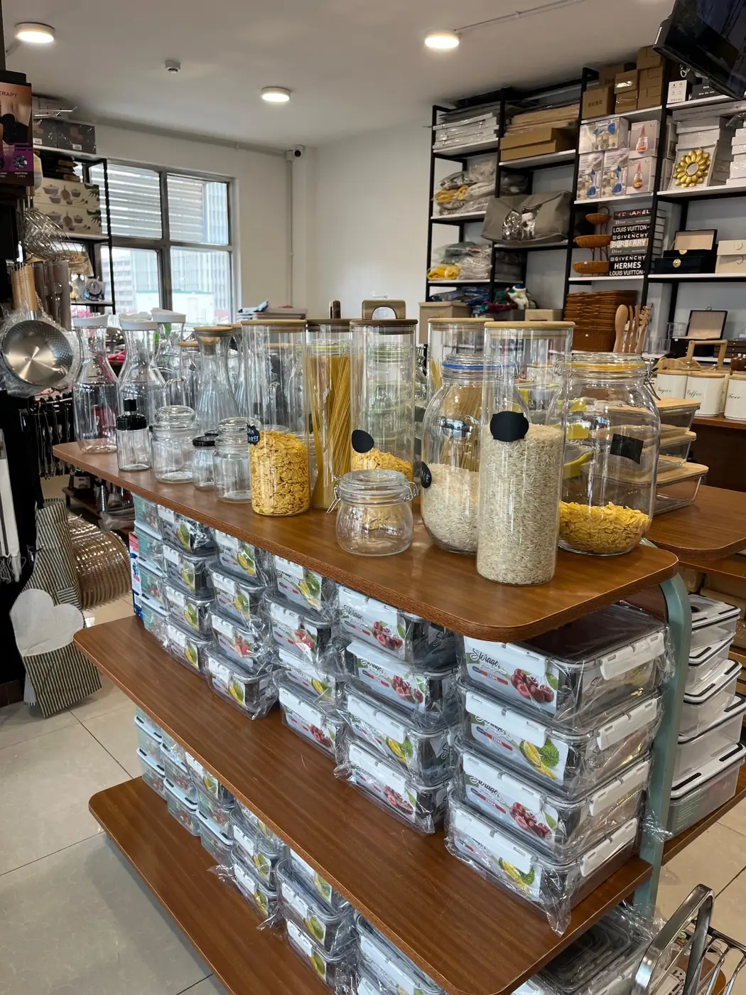 Glass pantry jars and food storage containers on a wooden display